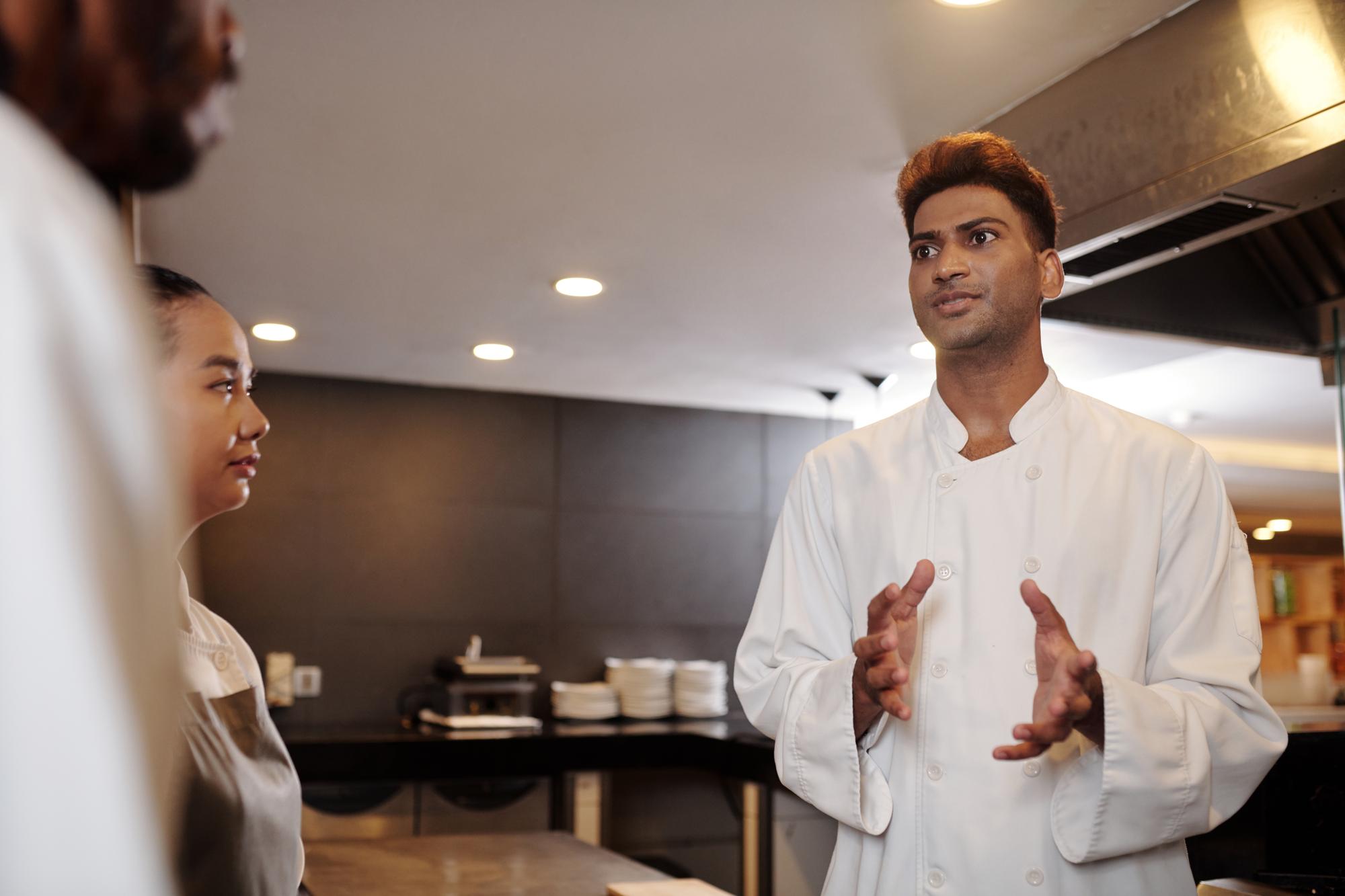 Chef and host conversing in a warm studio